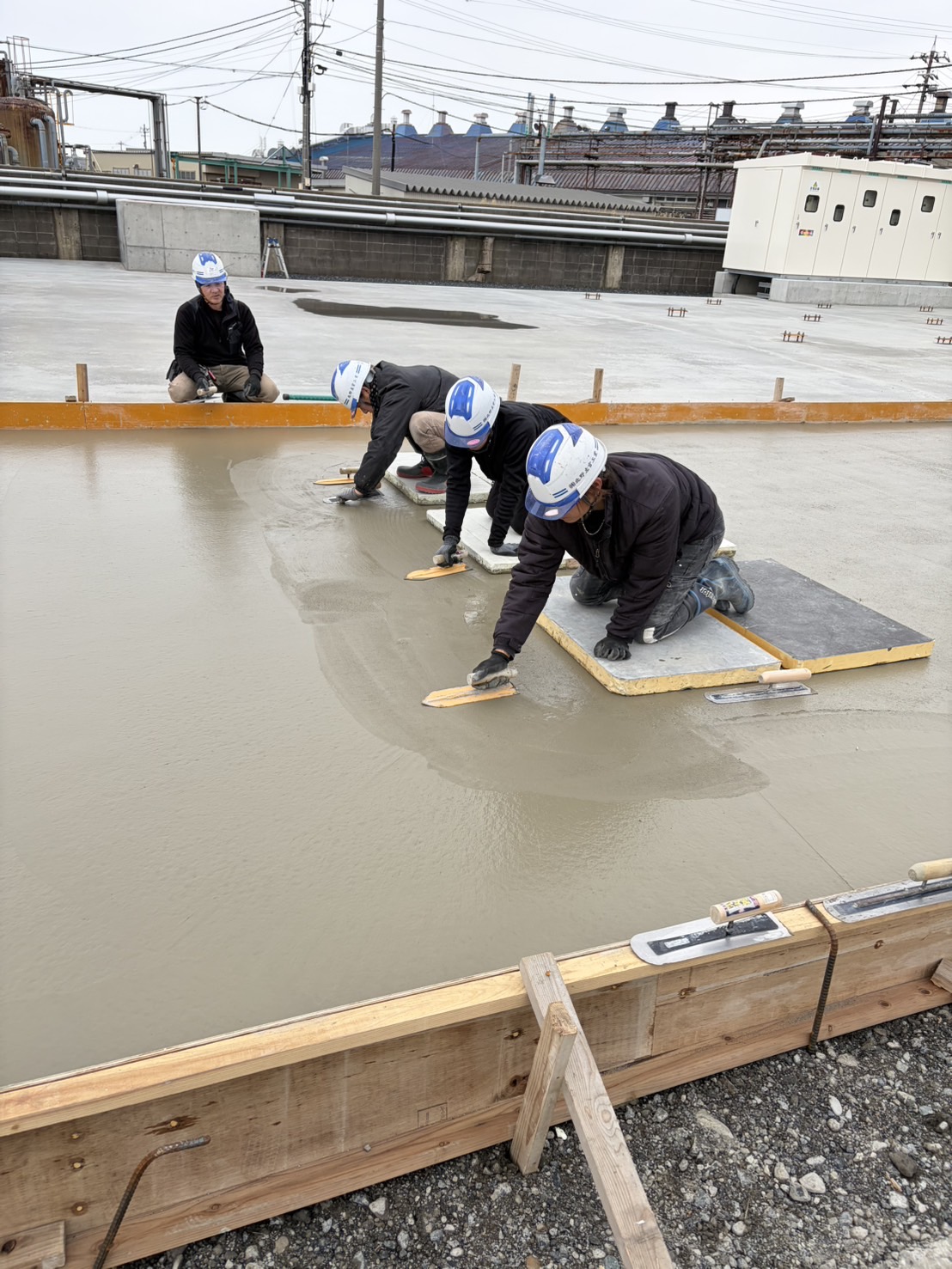 職人がコテを使い壁にモルタルを塗る左官作業の様子